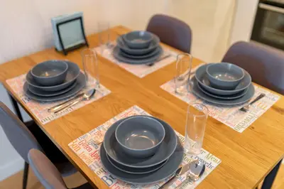 a wooden table with plates and glasses on top at Les appartements Privés Bar in Bar
