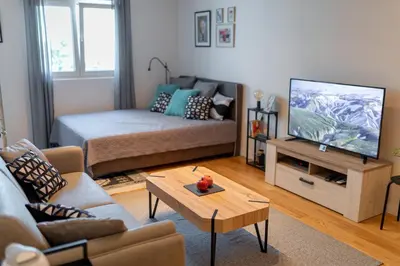 a living room with a couch and a tv at Les appartements Privés Bar in Bar