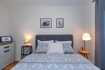 a bedroom with a bed with two lamps and two pictures on the wall at Les appartements Privés Bar in Bar