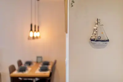 a toy boat hanging on a wall next to a table at Les appartements Privés Bar in Bar