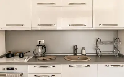 a kitchen with white cabinets and a sink at Four Views Apartments in Budva