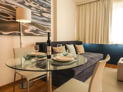 a dining room with a glass table and a couch at Four Views Apartments in Budva