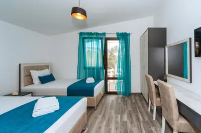 a hotel room with two beds and a table and chairs at Altea in Bar, Susanj