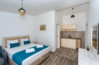 a bedroom with a large bed and a kitchen at Altea in Bar, Susanj