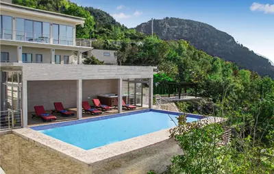 a house with a swimming pool next to a mountain at Awesome Home In Kotor in Kotor