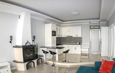 a kitchen and living room with white cabinets and a fireplace at Awesome Home In Kotor in Kotor