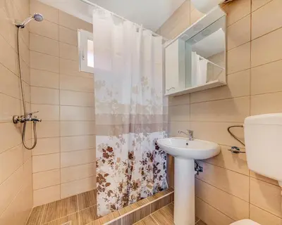 a bathroom with a sink and a shower curtain at S&M Apartments in Rijeka Crnojevića