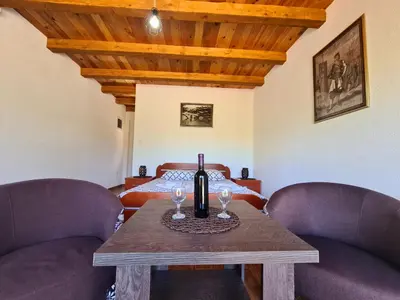 a room with a table with a bottle of wine on it at S&M Apartments in Rijeka Crnojevića