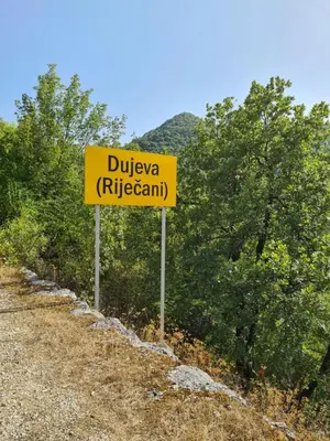 a yellow sign on the side of a dirt road at S&M Apartments in Rijeka Crnojevića