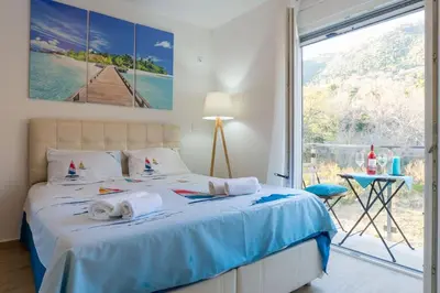 a bedroom with a bed and a large window at HAPPY HOME in Tivat