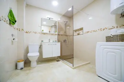 a bathroom with a toilet and a glass shower at HAPPY HOME in Tivat