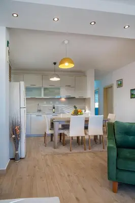 a kitchen and dining room with a table and chairs at HAPPY HOME in Tivat
