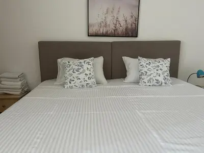 a bed with white sheets and pillows in a bedroom at Apartments Kuljaca in Budva