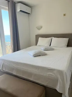 a bed in a room with a large window at Apartments Kuljaca in Budva