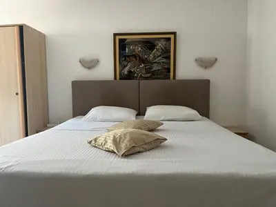 a large white bed with two pillows on it at Apartments Kuljaca in Budva