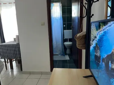 a living room with a tv and a bathroom at Apartments Kuljaca in Budva