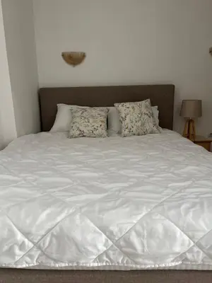 a bed with white sheets and pillows on it at Apartments Kuljaca in Budva
