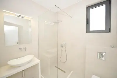 a white bathroom with a sink and a shower at Villa Zen Hill in Petrovac na Moru