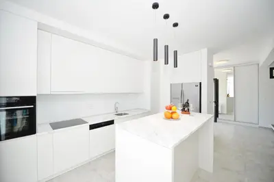 a kitchen with white cabinets and a bowl of oranges on a counter at Villa Zen Hill in Petrovac na Moru