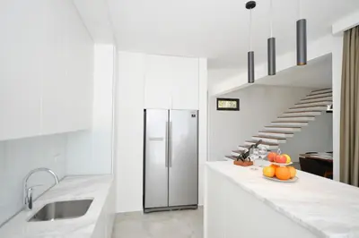 a kitchen with a counter with a refrigerator and a staircase at Villa Zen Hill in Petrovac na Moru
