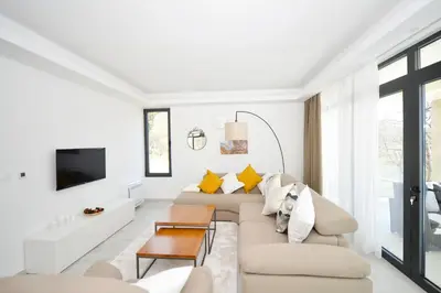 a white living room with a couch and a tv at Villa Zen Hill in Petrovac na Moru