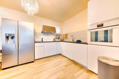 a kitchen with white cabinets and a stainless steel refrigerator at Villa Panorama Hill in Dobra Voda