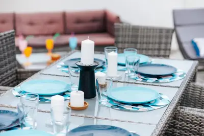 a table with blue plates and candles on it at Villa Panorama Hill in Dobra Voda