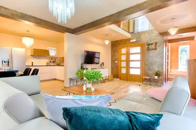 a living room with a white couch and a kitchen at Villa Panorama Hill in Dobra Voda