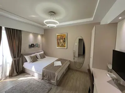 a bedroom with a large bed and a television at Hotel Holiday in Podgorica