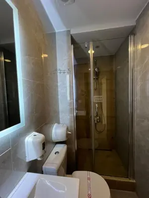 a bathroom with a shower and a toilet and a sink at Hotel Holiday in Podgorica