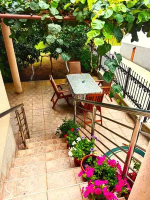 a patio with a table and chairs and flowers at El Mar Apartments in Budva