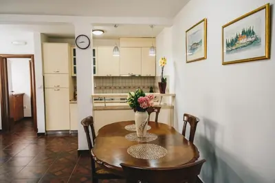 a kitchen and a table with a vase of flowers on it at El Mar Apartments in Budva