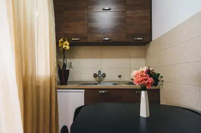 a kitchen with a table and a sink and a vase of flowers at El Mar Apartments in Budva