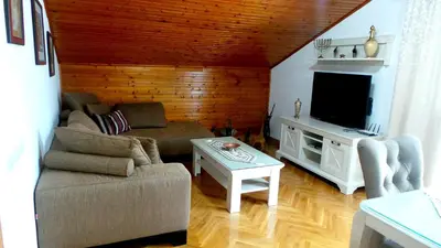 a living room with a couch and a tv at El Mar Apartments in Budva