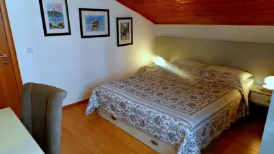 a bedroom with a bed and two pictures on the wall at El Mar Apartments in Budva