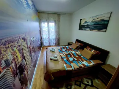 a bedroom with a bed with a painting on the wall at New York - Central Point in Podgorica