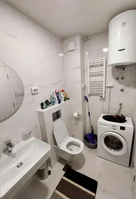 a white bathroom with a toilet and a sink at New York - Central Point in Podgorica
