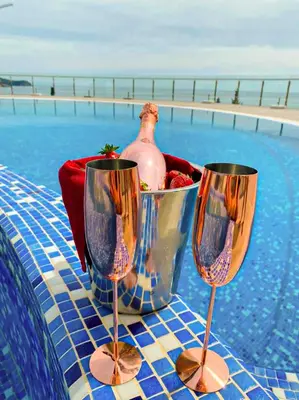 a table with two wine glasses next to a pool at Villa Allende in Budva