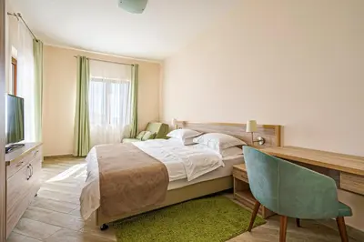 a bedroom with a bed and a desk and a chair at Villa Allende in Budva