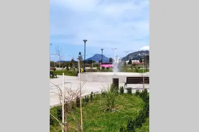 a park with a fountain and a park bench at Soho City Apartment with Garage in Bar
