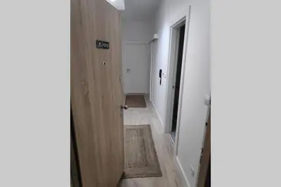 a hallway with a wooden door and a hallway with a rug at Soho City Apartment with Garage in Bar