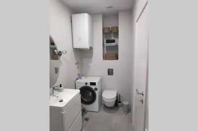 a bathroom with a toilet and a washing machine at Soho City Apartment with Garage in Bar