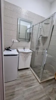 a bathroom with a shower and a sink and a mirror at Apartments Val Maslina in Utjeha