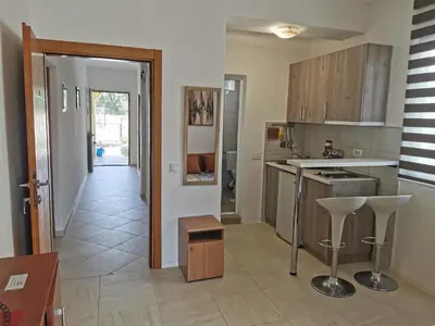 a kitchen with a counter and a table and chairs at Apartments Val Maslina in Utjeha
