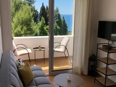 a living room with a couch and a large window at Apartments Lungo Mare Ulcinj in Ulcinj
