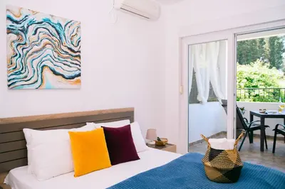 a bedroom with a bed with colorful pillows at Apartments Lungo Mare Ulcinj in Ulcinj