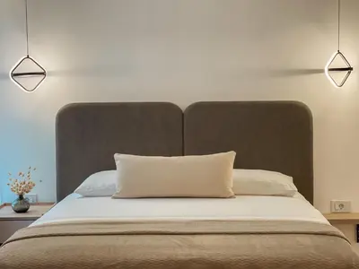a bed with a large headboard and a white pillow at Casa Nita in Ulcinj
