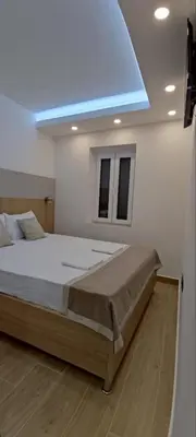 a bedroom with a large bed with a blue ceiling at SYMPHONY in Petrovac na Moru