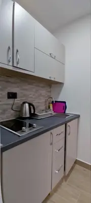 a kitchen with white cabinets and a stove top oven at SYMPHONY in Petrovac na Moru
