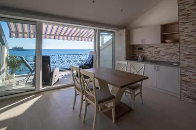 a kitchen and dining room with a view of the ocean at SYMPHONY in Petrovac na Moru
